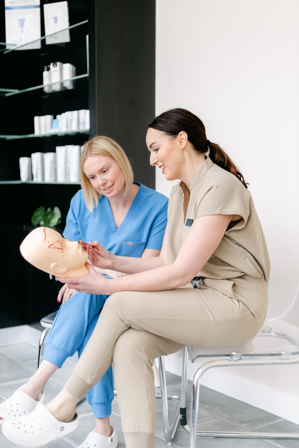 Sarah teaching injection technique on an anatomy training head with a delegate